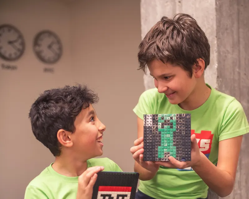 Due bambini mostrano i modelli LEGO che hanno appena costruito