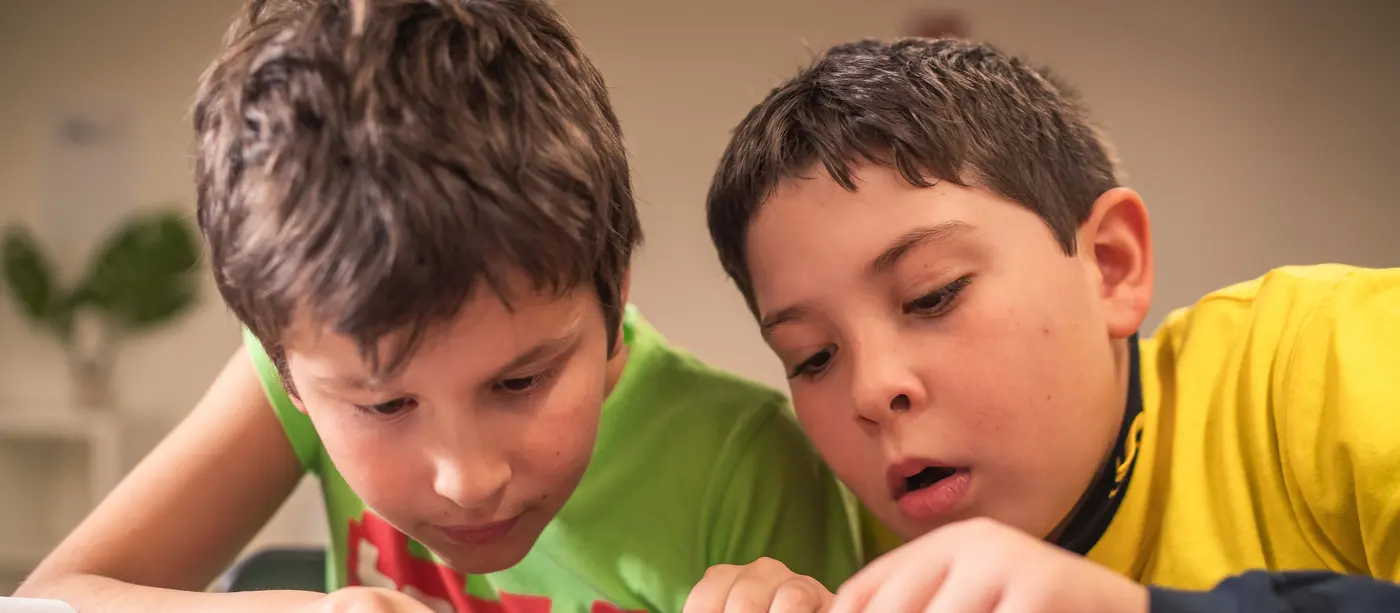 Due bambini concentrati montano un modello LEGO durante un laboratorio Bricks 4 Kidz