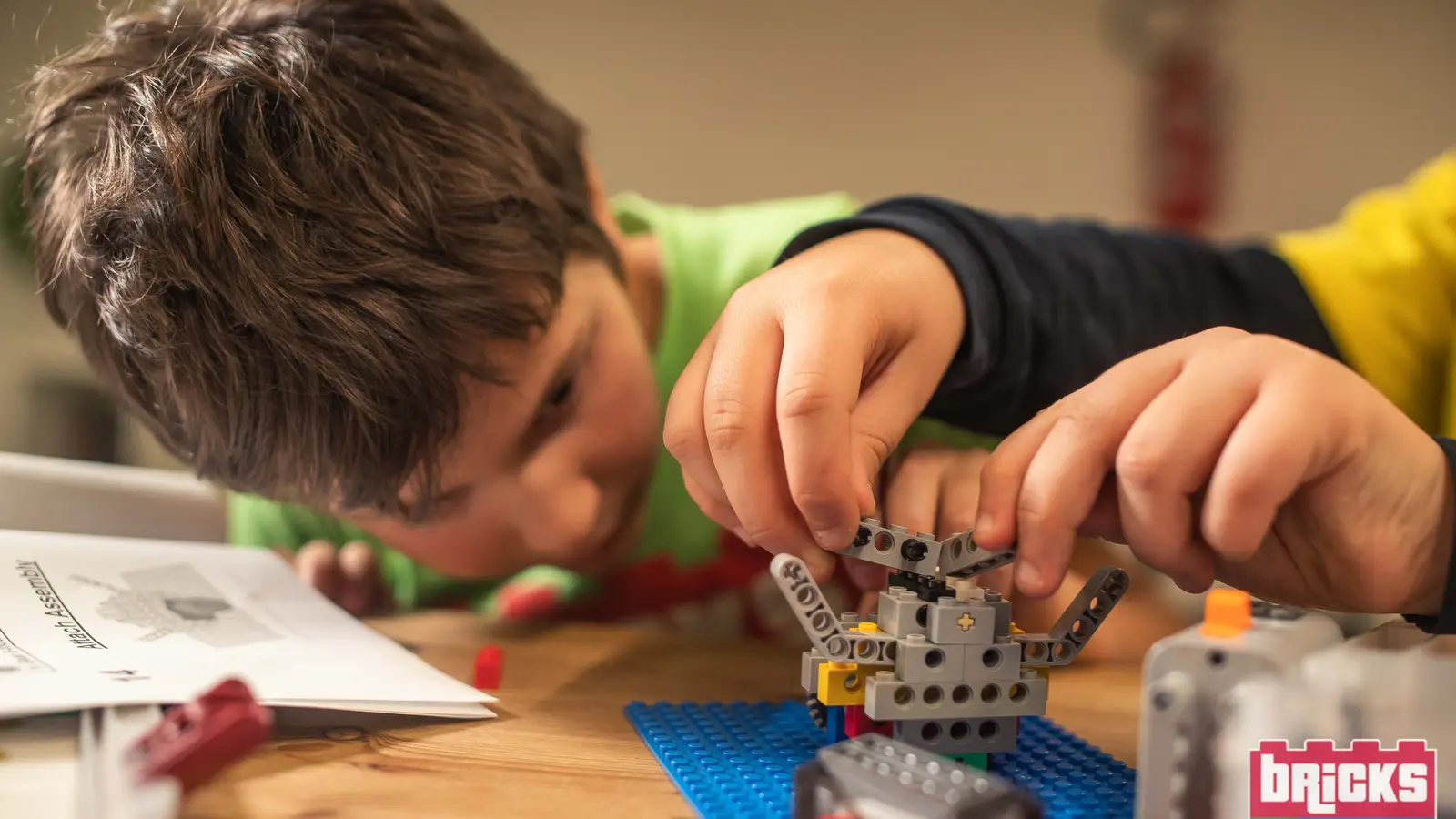 Un bambino monta un modello LEGO con ingranaggi durante un laboratorio Bricks 4 Kidz