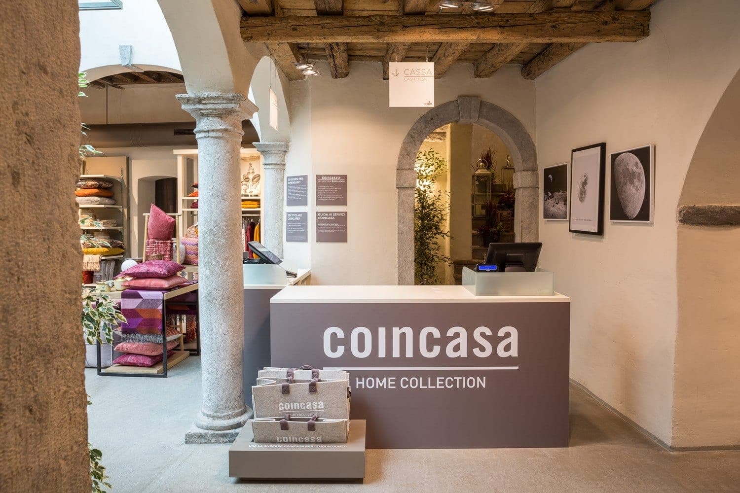Interno di un negozio Coincasa con banco cassa brandizzato sotto volte in pietra