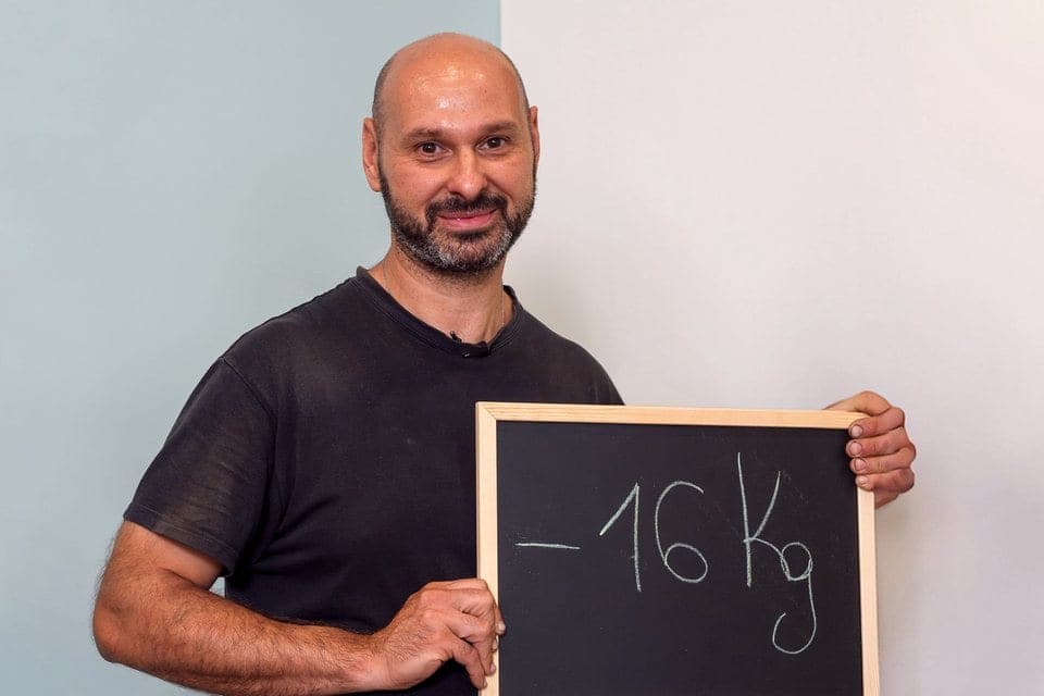 Cliente Diètnatural seduto in un centro con la lavagna dei chili persi: -16 kg