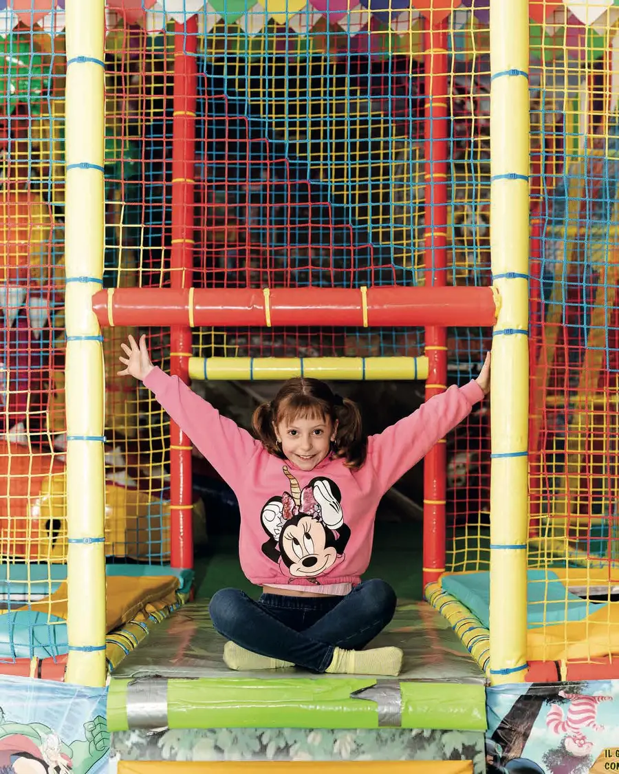 Bambina con le braccia alzate nel playground su più livelli del Ruggito del Coniglio