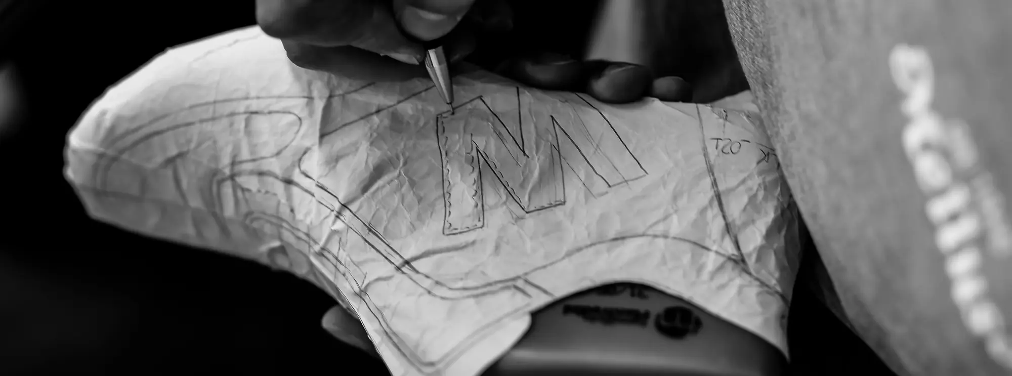 Un modellista Melluso disegna a matita la M sulla forma di una scarpa, nella fabbrica di Napoli