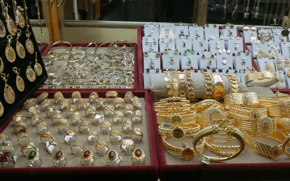 Vassoi di anelli e bracciali d'oro nella vetrina di un negozio