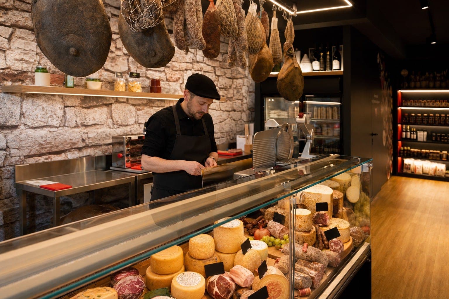 Interno della bottega Quintovizio con banco di salumi e formaggi toscani