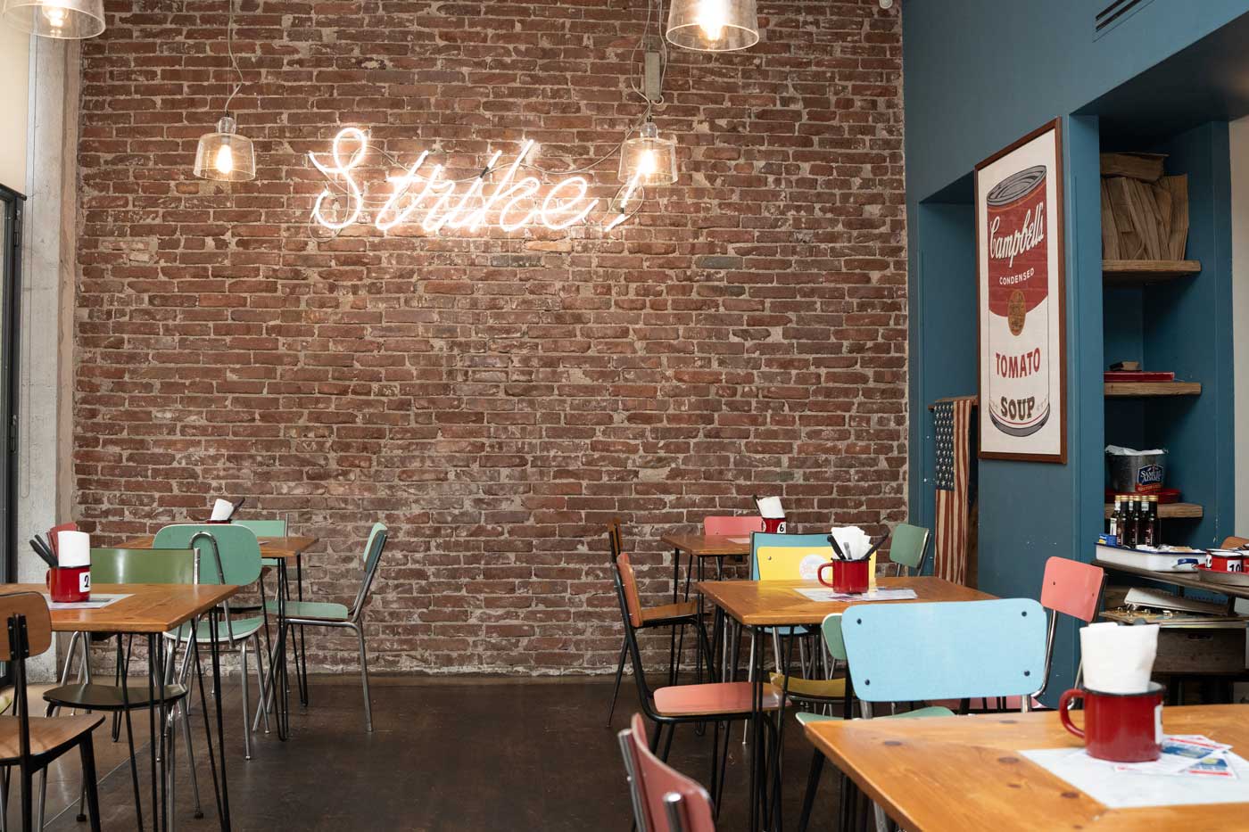Interno del locale Strike! Burger con insegna al neon