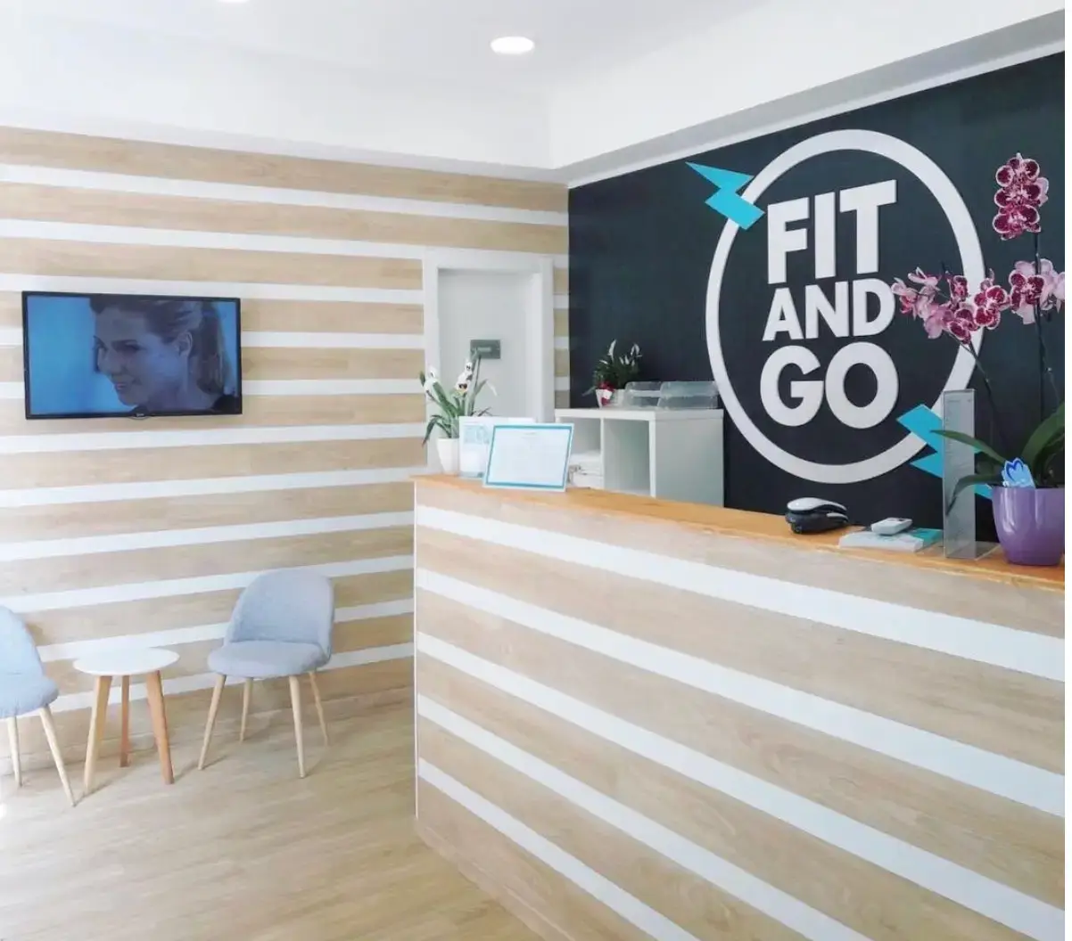 Accueil d'un studio FitAndGo, design bois et blanc, signalétique de marque